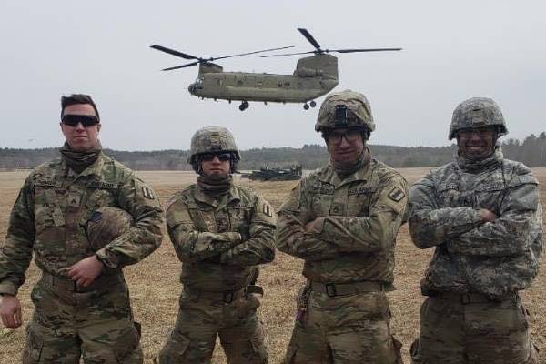 Sam with Army friends in front of Helicopter